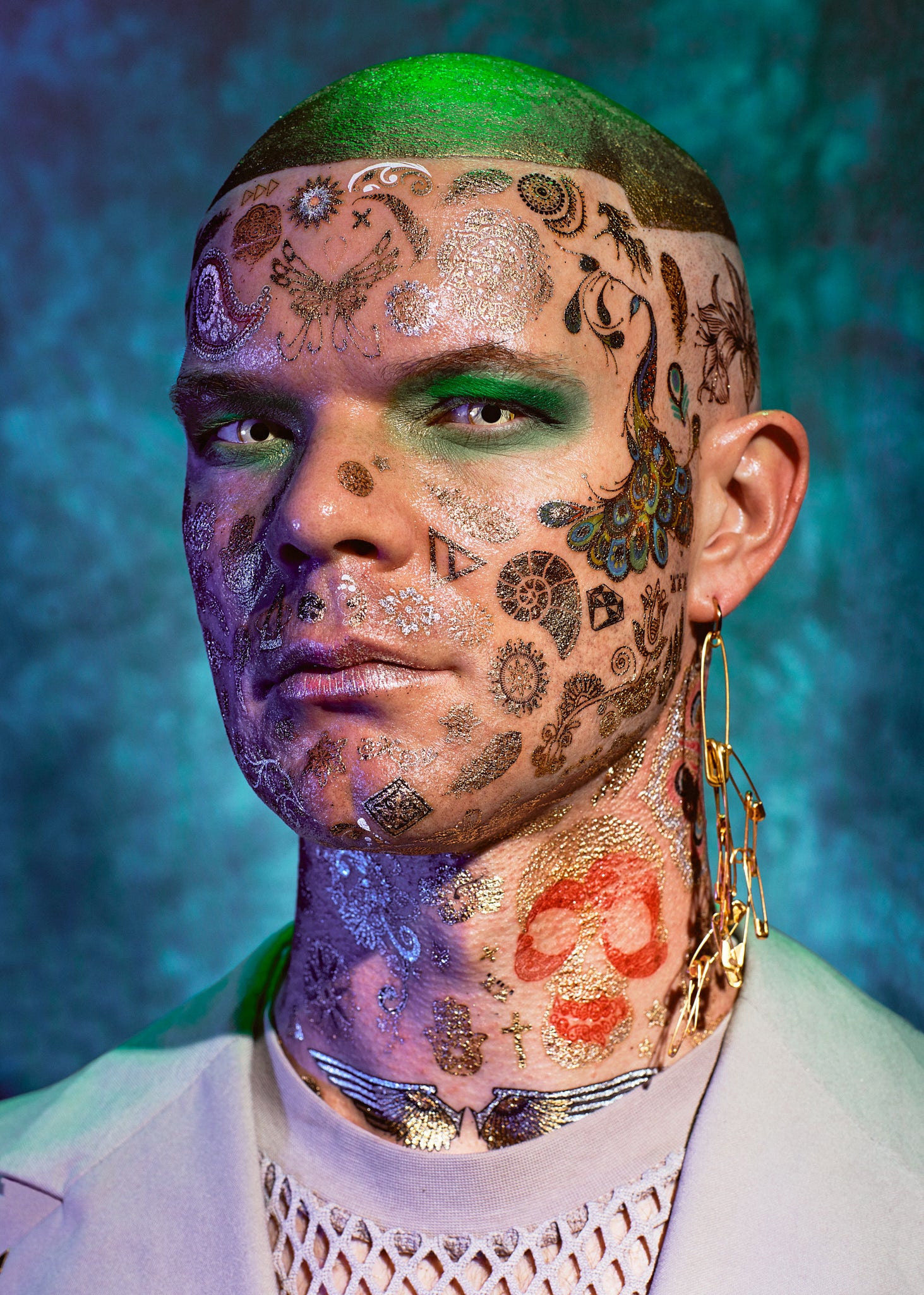 Image of a Voguer with hand drawn tattoos on his face looking directly to camera, in a studio environment, captured at the Mystic Ball in Copenhagen