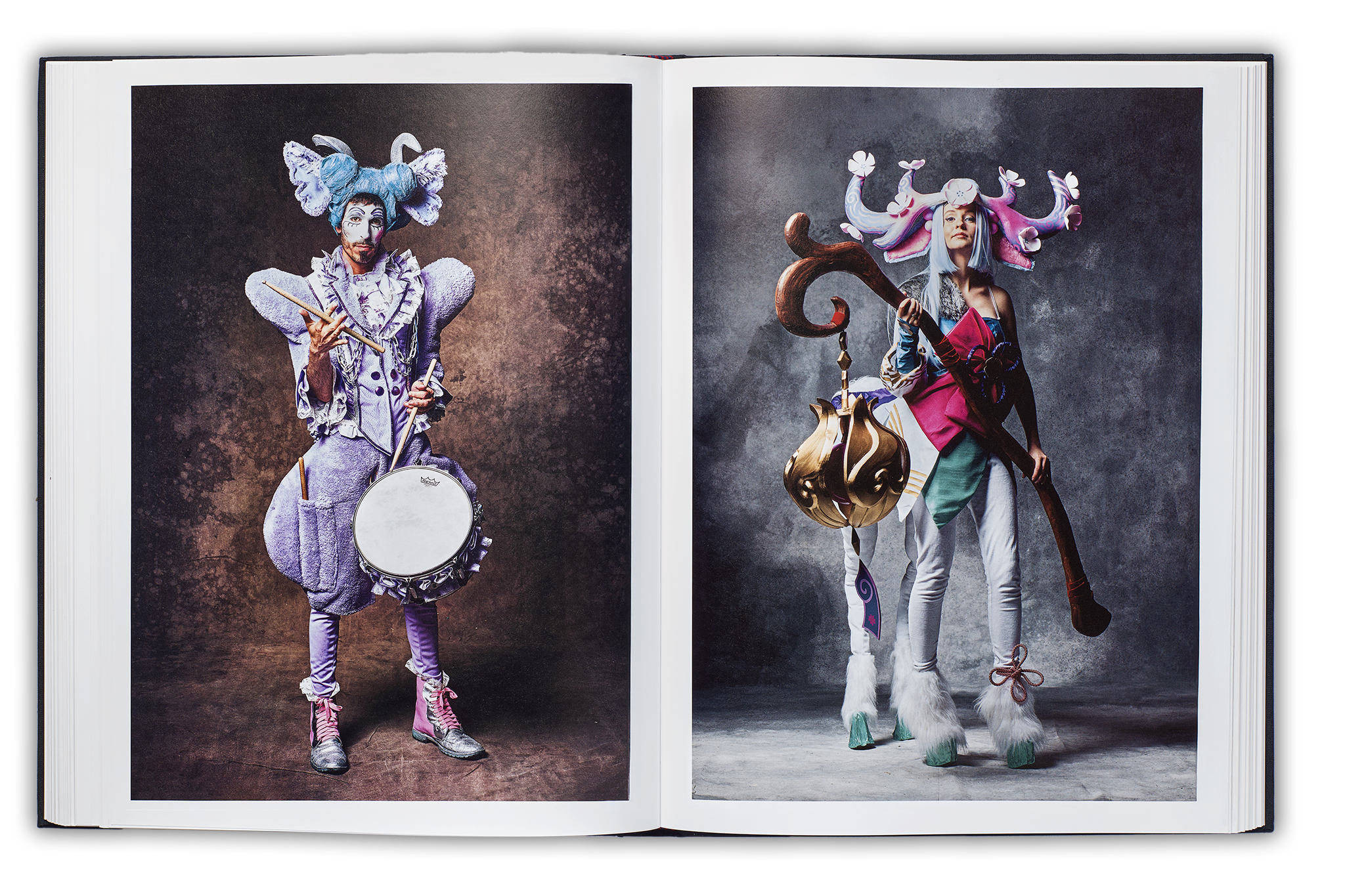 Mayflies book spread, left page: Carnvalist with blue hair and pink outfit with a snare drum twirling a drumstick, right page centaur cosplayer with pink antlers