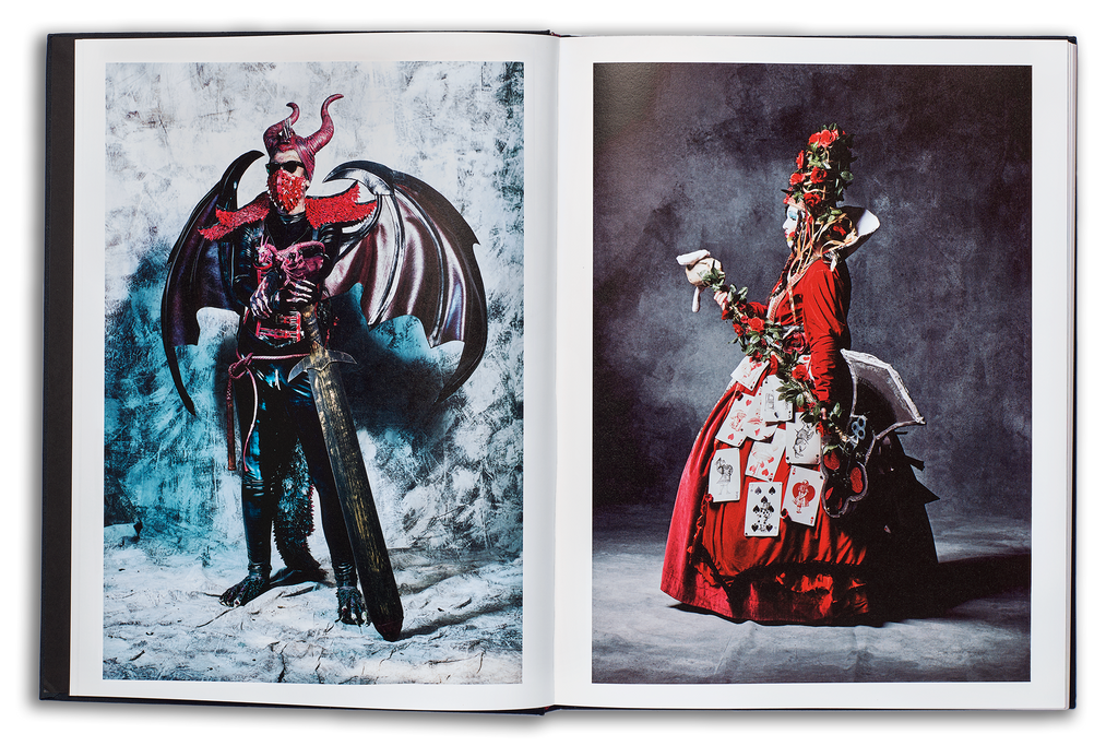 Mayflies book open spread, left page: rock in roll demoness with black wings, sunglasses, and red horns holding a sword, right page: the Queen of Hearts cosplayer in a scarlet dress holding an axe
