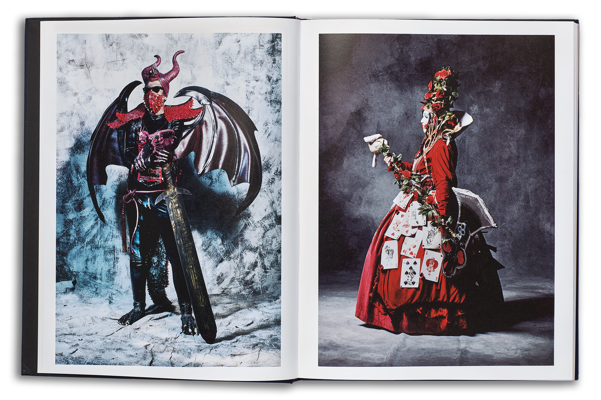 Mayflies book open spread, left page: rock in roll demoness with black wings, sunglasses, and red horns holding a sword, right page: the Queen of Hearts cosplayer in a scarlet dress holding an axe